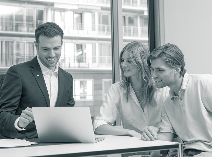 Beratungsgespräch zwischen Degussa-Mitarbeiter und Kunden in modernem Büro mit Laptop