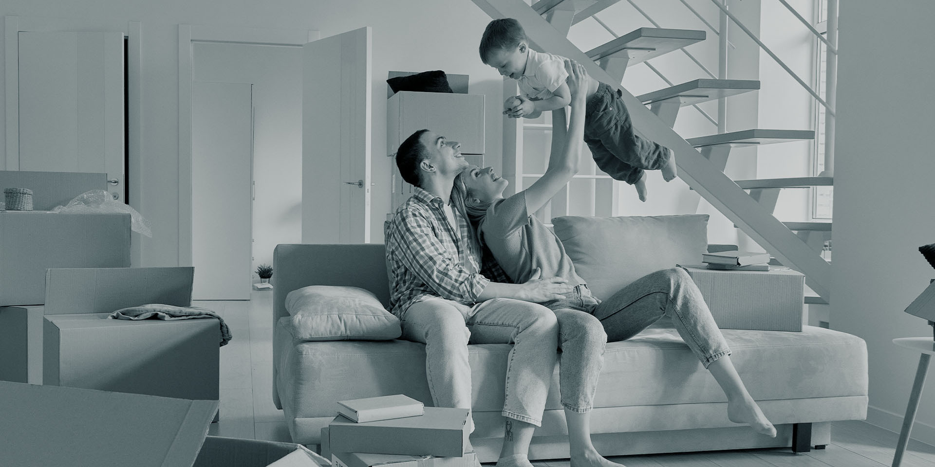 Junge Familie beim Einzug ins neue Zuhause, lacht und spielt miteinander