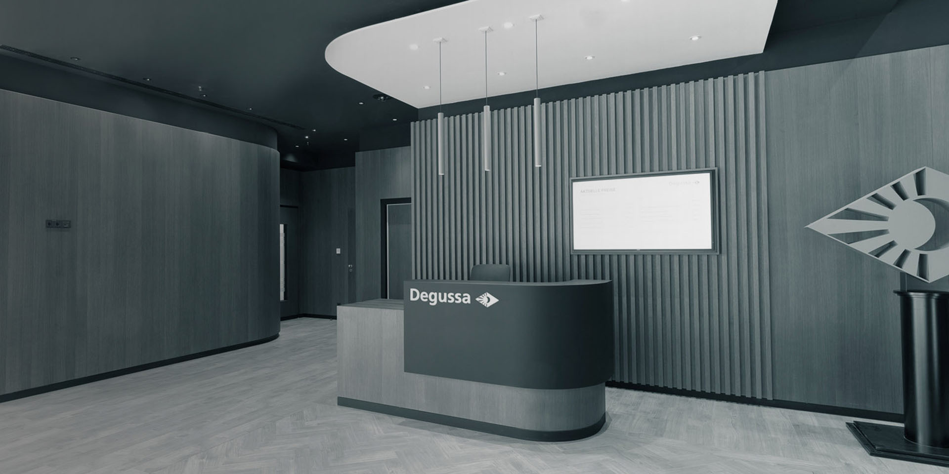 Moderner Degussa-Empfangsbereich mit Logo, Empfangstresen und hölzerner Wandgestaltung.