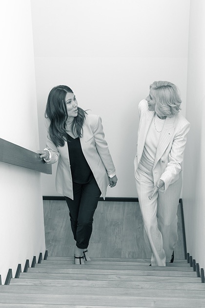 Zwei Frauen unterhalten sich auf einer modern ausgebauten Treppe