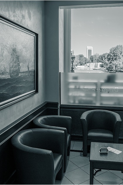 Wartebereich der Hamburger Niederlassung mit bequemen braunen Sesseln und einem großen Gemälde an der Wand