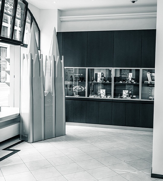 Innenansicht der Degussa Niederlassung in Köln mit einer großen Skultpur des Doms und Vitrinen mit Goldprodukten an der Wand