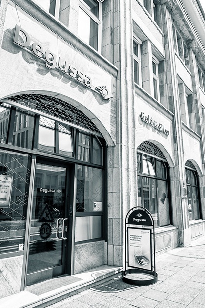 Außenansicht der Eingangstür zur Kölner Niederlassung mit Rundbogen und einem Gehwegaufsteller