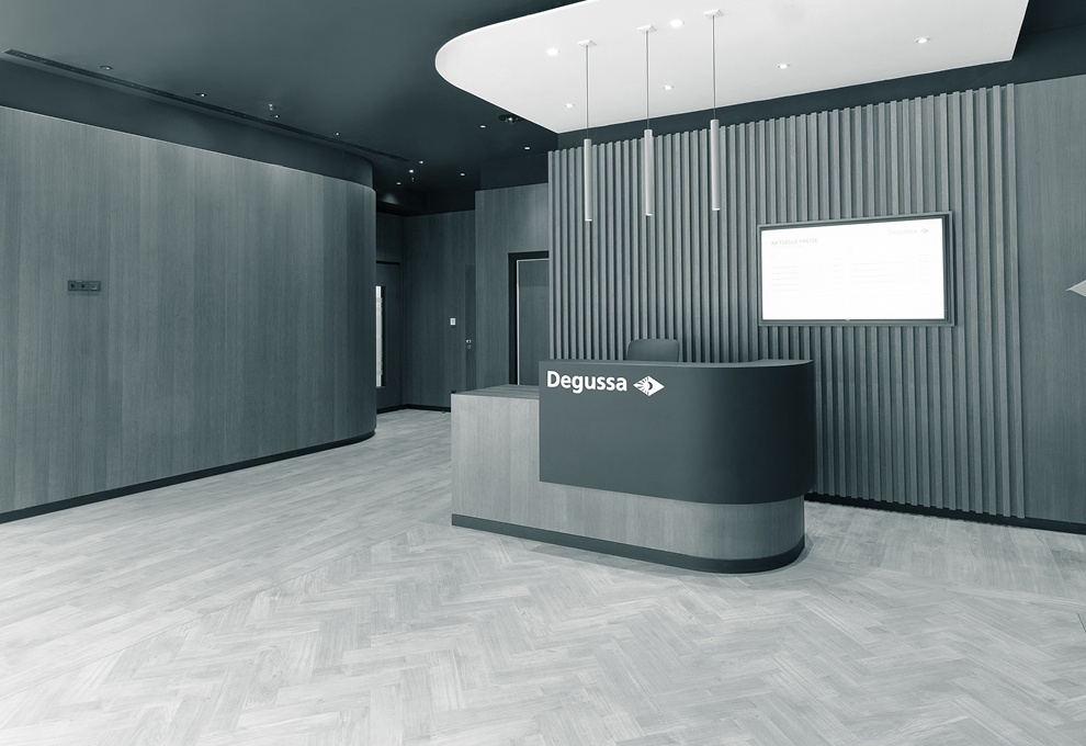 Eingangsbereich der Niederlassung Frankfurt mit einem modernen Pult mit Degussa-Logo, schicker Holzwand und ästhetischen Lampen