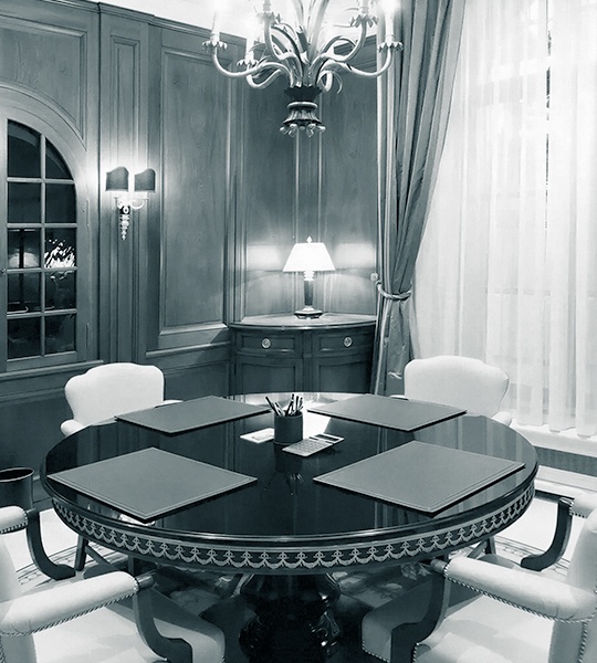 Eleganter Besprechungsraum der Degussa Dubai mit rundem Holztisch und luxuriöser Wandtäfelung.