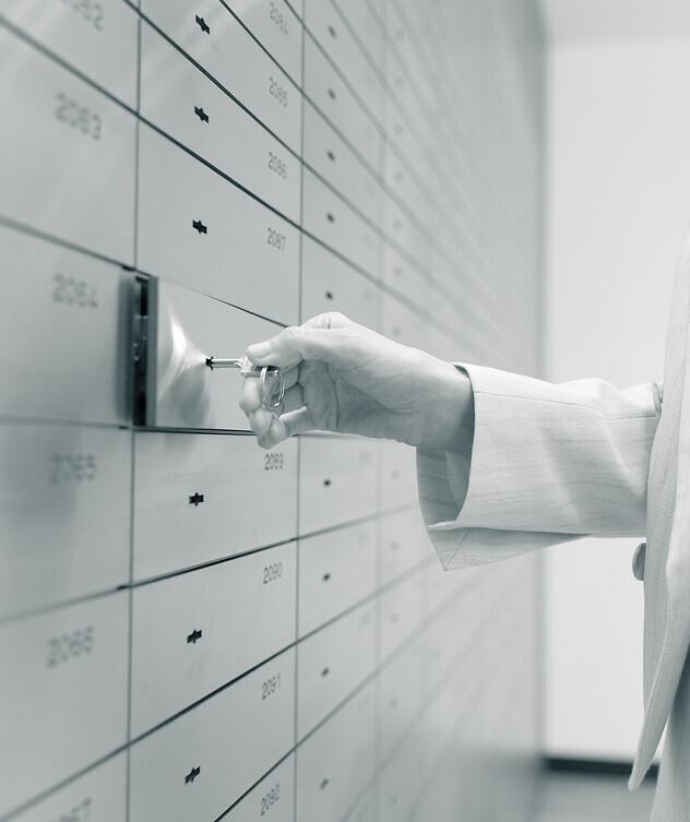 Nahaufnahme der Hand einer Frau, die in einer Wand aus Schließfächern ein einzelnes mit dem Schlüssel öffnet.